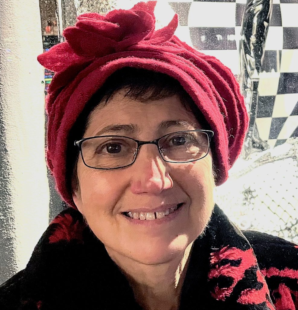 A picture of a woman in a red hat and red coat with glasses. 